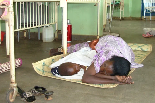 A mother lying on a bare floor at Kayunga pediatric ward, Uganda. Photo: Vincent Mayanja/IRIN