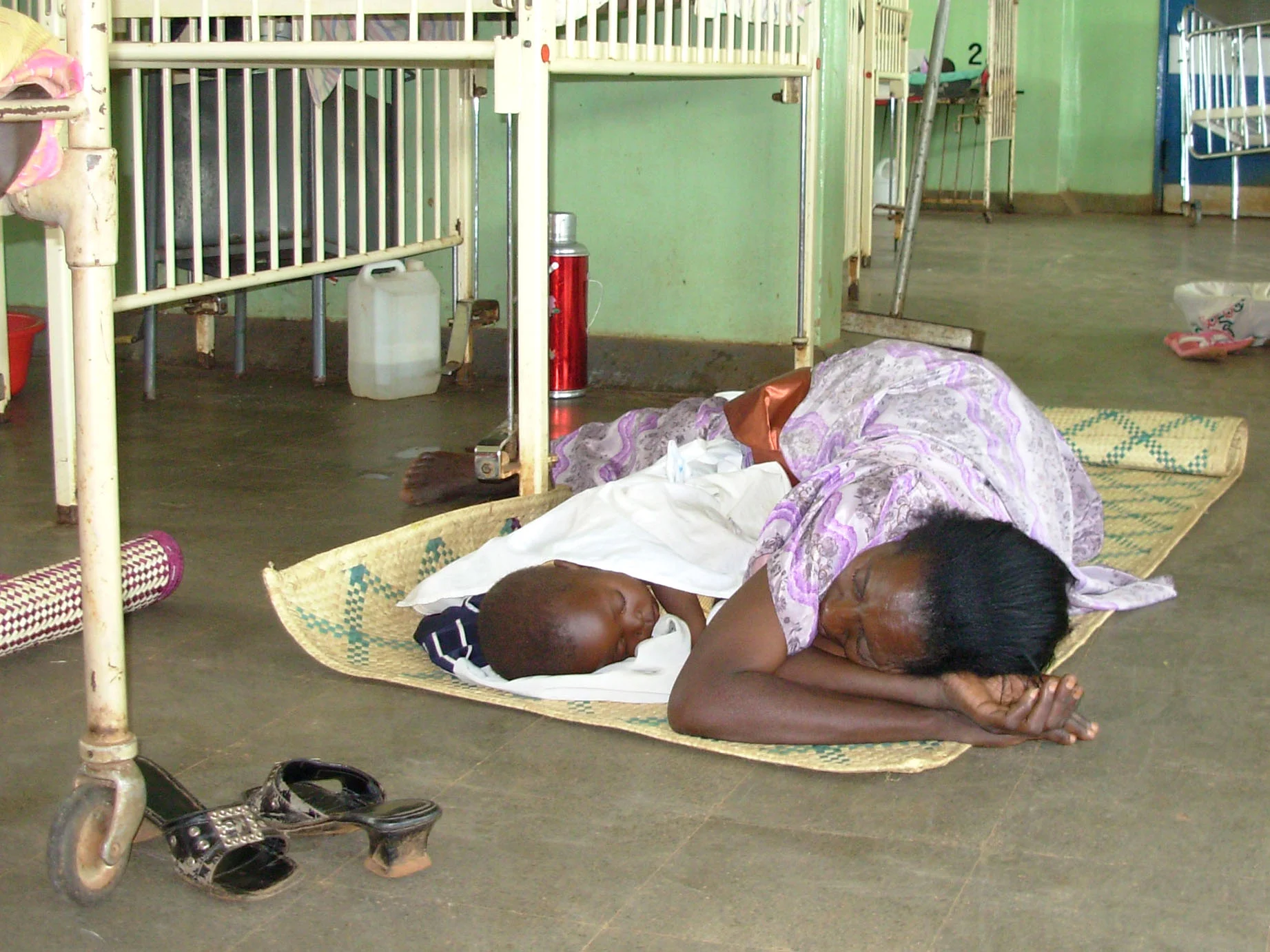 A mother lying on a bare floor at Kayunga pediatric ward, Uganda. Photo: Vincent Mayanja/IRIN
