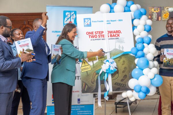 Kirstine Primdal Sutton of the Royal Danish Embassy signs a ceremonial copy of the Press Freedom Index Report 2024 Uganda at the HRNJ launch event.